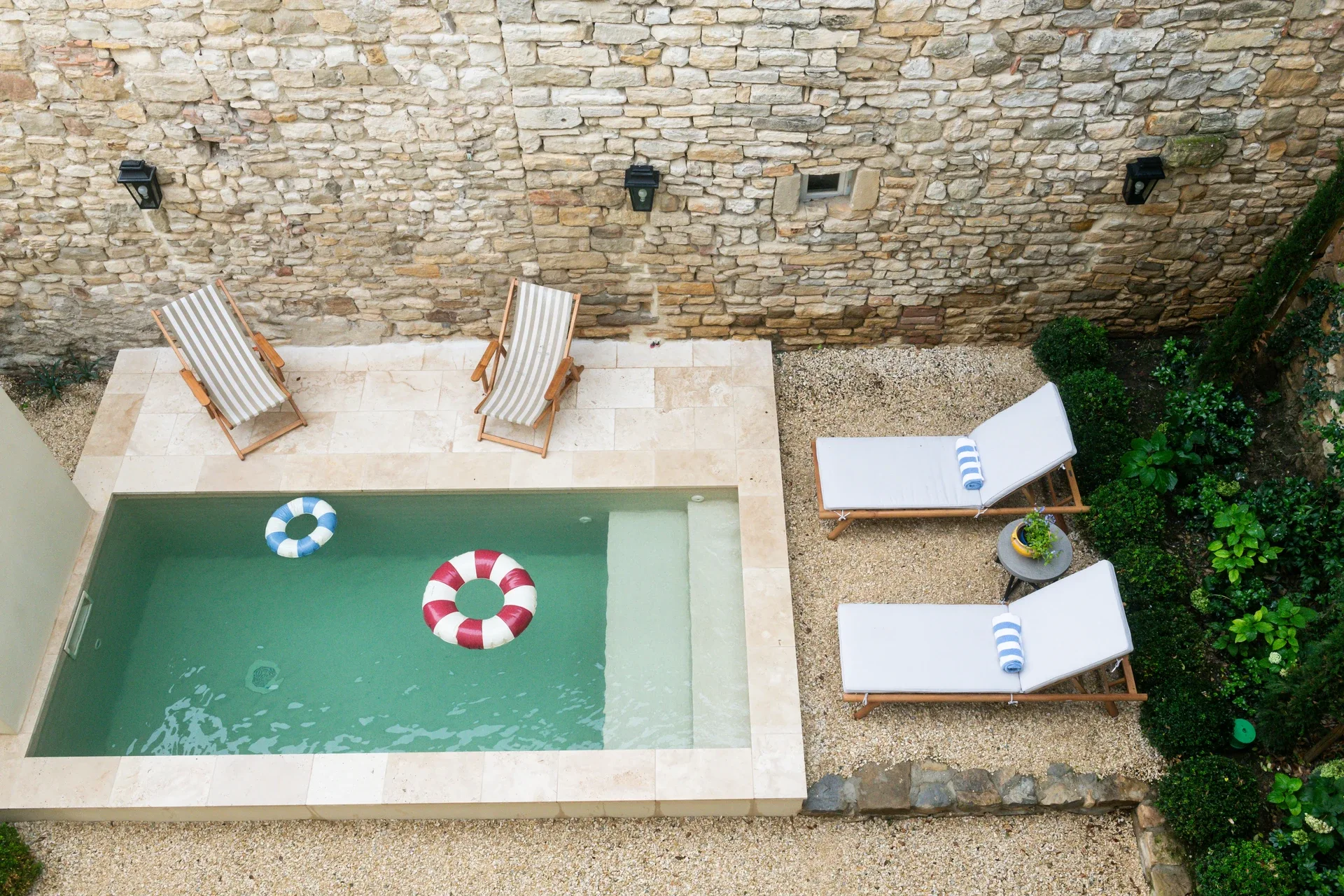 An overhead view of the plunge pool at Maison de Frederic, deckchairs and loungers beside it